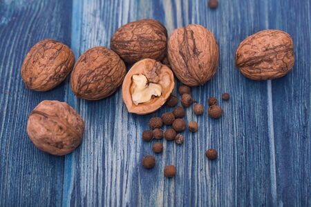Walnuts and small spices on blue wooden table