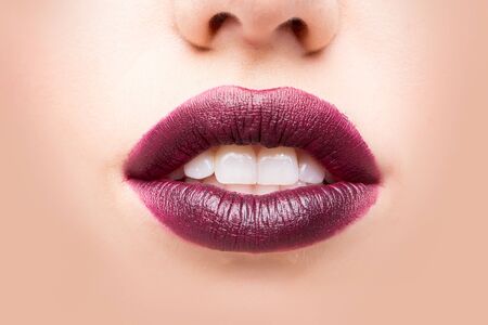Female open mouth with sexy lips purple lipstick and white teeth closeupの写真素材