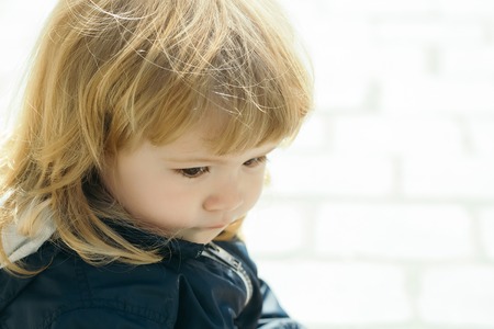 Small male kid with blond curly hair sunny day outdoor closeup, copy spaceの写真素材