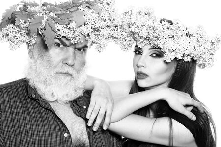 Bearded man and beautiful woman in lilac wreathes hug black and whiteの写真素材
