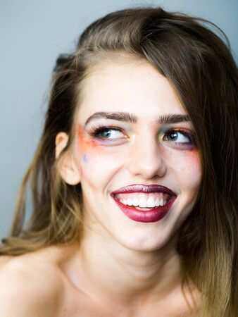 Young girl with pretty smiling face and bright orange makeup in studio closeupの写真素材