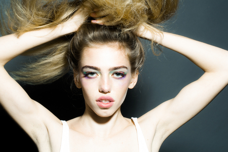 Young girl with pretty face and long lush hair on grey background in studioの写真素材