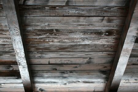 Old wood ceiling with beams on timber backgroundの写真素材