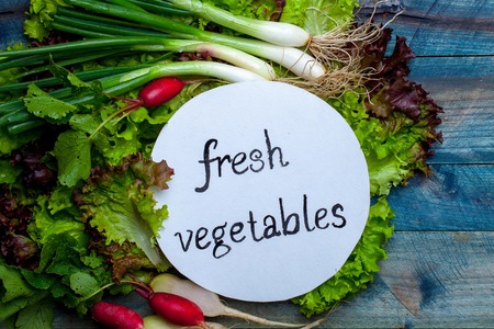 Scallions red white radish and green lettuce with note fresh vegetables on wooden backgroundの写真素材