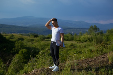Young handsome man with muscular sexy body standing with laptop outdoor sunny day on blue sky backgroundの写真素材