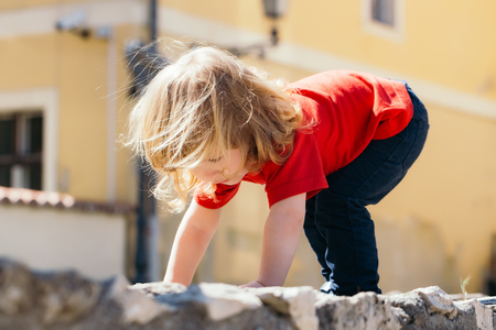 Adorable little boy stands up after the fallの写真素材