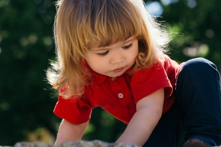 Adorable little boy with long hair up after the fallの写真素材