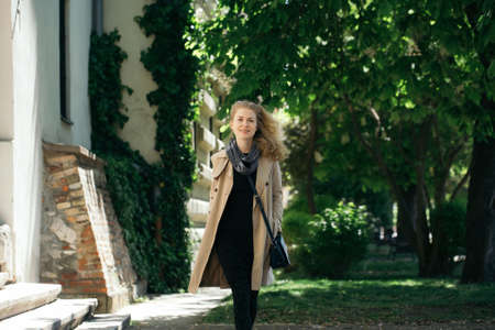 Pretty girl has nice walk in the park. Cute girl walks towards the cameraの写真素材