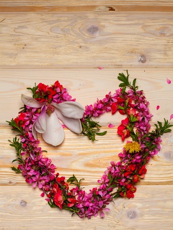 Beautiful flowers in heart shape on wooden backgroundの写真素材
