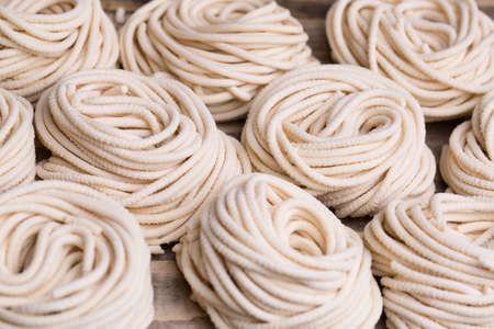Homemade tagliatelle dry italian pasta nest on wooden backgroundの写真素材