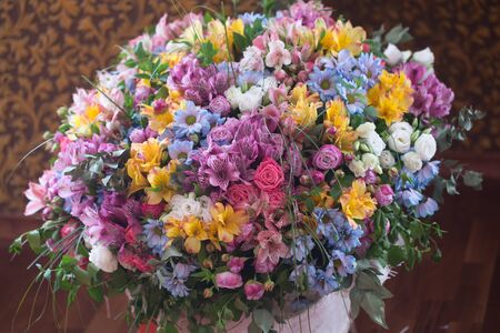 Beautiful bouquet of colorful blossoming flowers on brown backgroundの写真素材