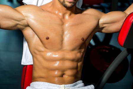 sexy muscular male torso six packs on wet body of athletic man training with bare chest and strong...
