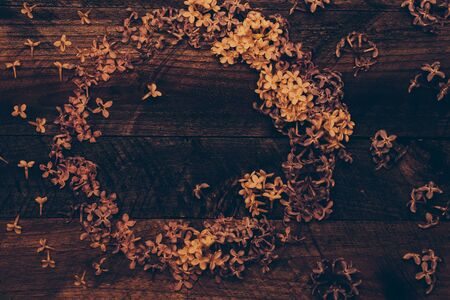 Lilac blossoming flowers decorative wreath on timber background
