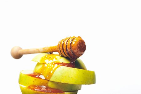 Fresh green cut apple lying in pyramid and wooden spoon with sweet honey isolated on white background, copy spaceの写真素材