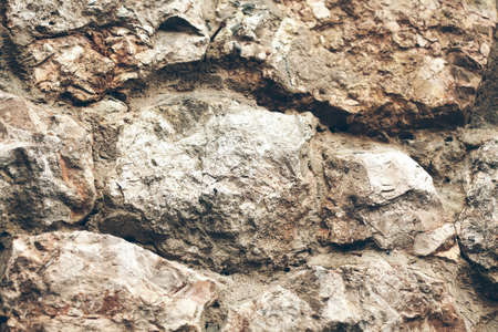 Rough wall of natural stones on brown backgroundの写真素材