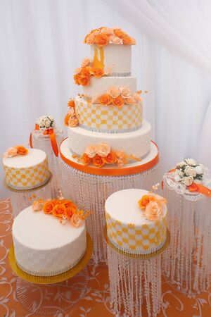 Wedding cakes big beautiful tasty many-tier decorated with orange flowers on white background