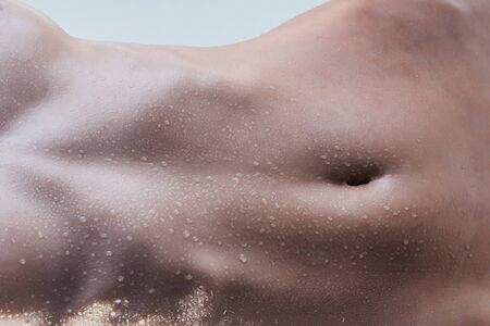 female naked belly on wet slim body with water drops of young sexy bare woman, closeupの写真素材