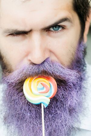 young handsome bearded man with long beard blue color and emotional face in white shirt eating...