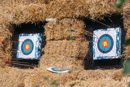 Archery targets with arrows on rural shooting range outdoors on haystack backgroundの写真素材