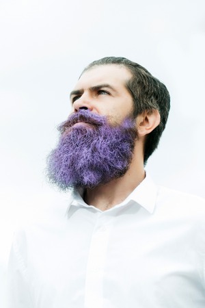 young handsome bearded man with long beard blue color and smiling face in white shirt, closeupの写真素材