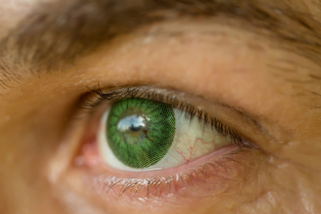 male eye with bright dotty lens green color and hairy eyebrow of old man with wrinkled skin, closeupの写真素材