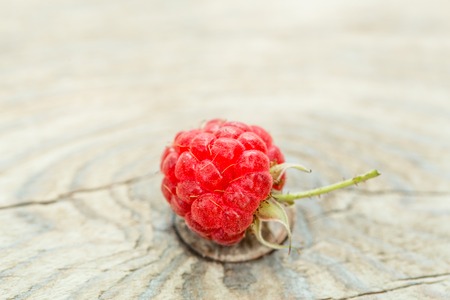 wild berry of fresh natural healthy red raspberry with green leaves on wooden backgroundの写真素材