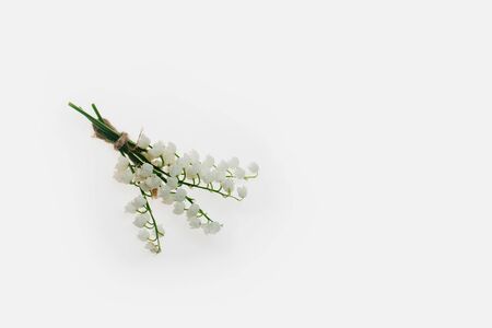 seasonal lily of valley flower bouquet on green stem with rope in spring isolated on white background, closeup, copy spaceの写真素材