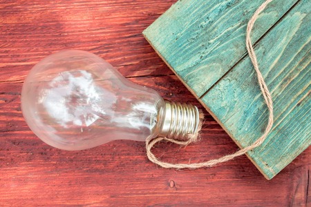 Incandescent light bulb electric glass with rope on wooden backgroundの写真素材