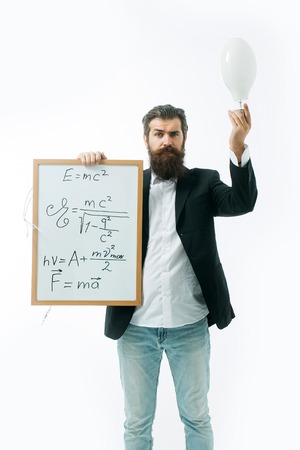 young handsome bearded man scientist or professor with long beard holding teacher board with einstein formula and newtons law isolated on white backgroundの写真素材