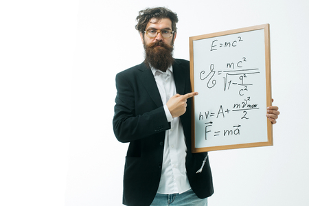 young handsome bearded man scientist or professor in glasses with long beard holding teacher board with einstein formula and newtons law isolated on white backgroundの写真素材