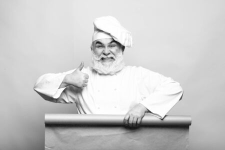 Cook holding parchment paper, copy space, black and white