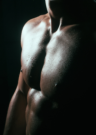 Sexy macho man with bare chest and beautiful body standing in studio