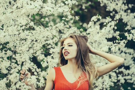Beautiful happy young woman enjoying beauty in a flowering spring gardenの写真素材