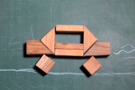 Wooden blocks figure car construction build on green school blackboard backgroundの写真素材