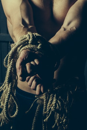 Closeup of a tied bare-chested young male handsの写真素材