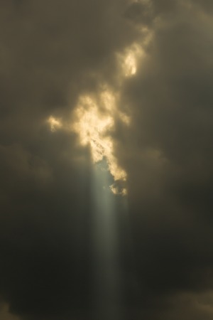 A ray of sunlight breaking through dark cloudsの写真素材