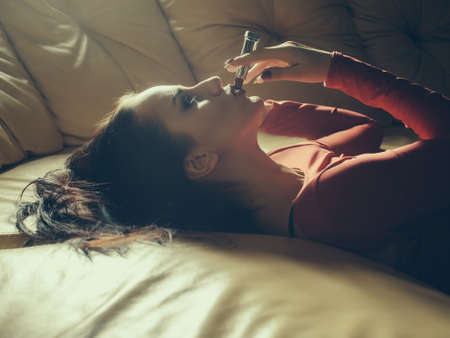 Attractive girl with red lipstick on the beige couchの写真素材