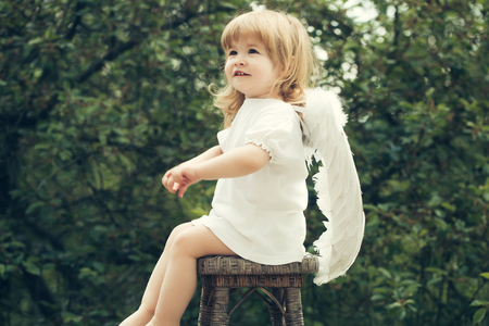 Little angel landed on the chair. Cute boy is the angel costumeの写真素材