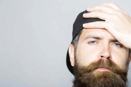 Close up of handsome man with long beard and a baseball capの写真素材