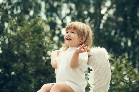 Little cupid boy with white wings is happyの写真素材