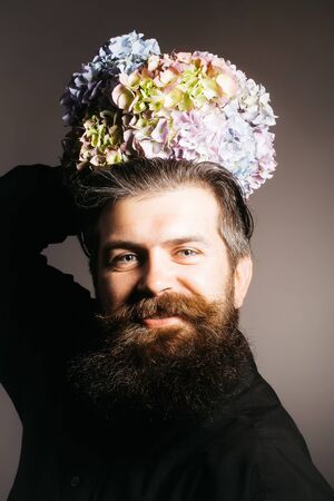 handsome sexy bearded young man hipster with floral beard and mustache on smiling face in studio...