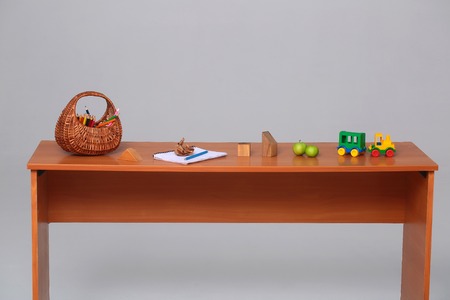 Different school supplies in a row on the brown deskの写真素材