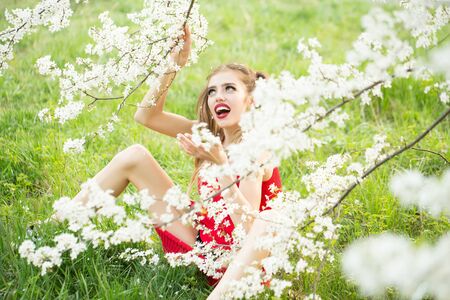 Beautiful happy young woman enjoying beauty in a flowering spring gardenの写真素材