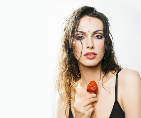 young woman with pretty face and wet hair holding red strawberry berry fruit in studio isolated on white background, copy spaceの写真素材