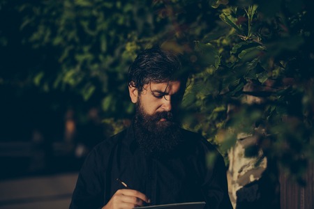 handsome bearded young man hipster with long beard and mustache has stylish hair on serious hairy...