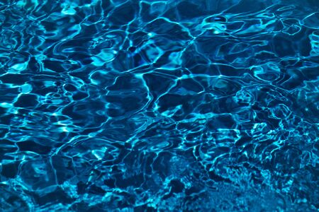 bright blue or turquoise color water background of swimming pool or sea and ocean beach glare with...