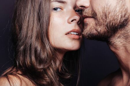 young couple of woman or girl with pretty face and long hair embrace handsome muscular unshaven manの写真素材
