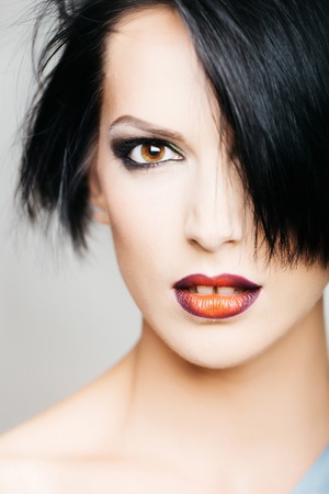 young woman or girl with stylish short brunette hair and fashionable glamour makeup on pretty face portrait has bright lipstick on lipsの写真素材