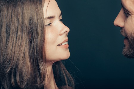 young couple of woman or girl with pretty face and long hair embrace handsome muscular unshaven manの写真素材