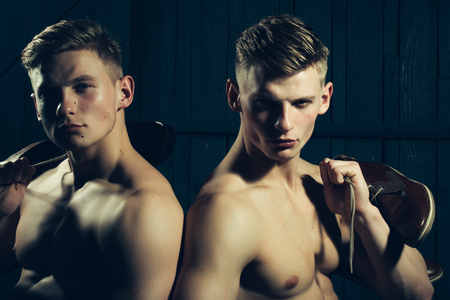 Two young male twins with sexy body showing their muscular torso and abs in studioの写真素材